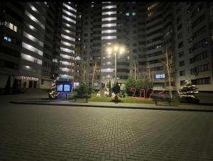a park with benches in front of a building at night at Airport Transit Studio Ночь перед вылетом in Chişinău