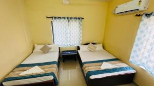 two twin beds in a room with a window at Arabian Shore - Udupi in Malpe