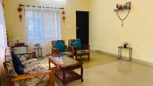 a living room with several chairs and a table at Arabian Shore - Udupi in Malpe