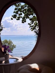 a view of the ocean through a round window at Baankonhualamkohlibong in Ko Libong Island