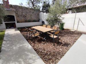 a patio with a table and chairs in a backyard at Blue Pearl Seafront in Preko