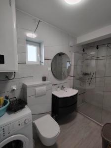 a white bathroom with a sink and a toilet at Blue Pearl Seafront in Preko