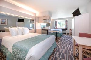 a hotel room with a large bed and a desk at Microtel Inn & Suites Claremore Route 66 in Claremore