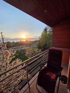 a chair on a balcony with a view of the sunset at Prespa Lakeview Villa in Resen
