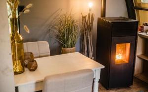 a room with a table and a fireplace with plants at Parc Boulée in Ven-Zelderheide