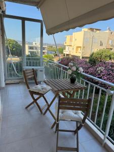 a patio with a table and chairs on a balcony at Sun Beach Apartment in Anavyssos