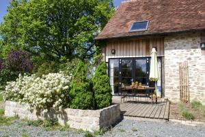 a house with a wooden deck with a table on it at vakantiewoning Odiel & Gabrielle in Montchevrier