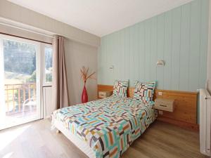 a bedroom with a bed and a large window at Gîte les Égravines in Mijoux
