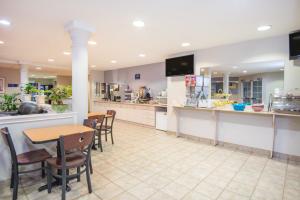un restaurante con mesa y sillas y una cocina en Microtel Inn & Suites Claremore, en Claremore