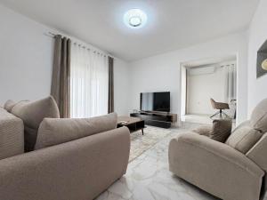 a living room with two couches and a television at Villa Ivanovic in Podgorica