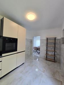 a kitchen with white cabinets and a microwave at Villa Ivanovic in Podgorica