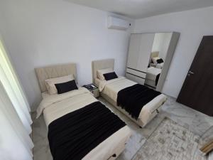 two beds in a room with a mirror at Villa Ivanovic in Podgorica