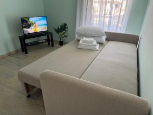 a living room with a couch and a tv at Sun Beach Apartment in Anavyssos