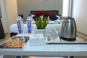 a table with a tray of food and water and flowers at Hotel Nirmal's Executive in Pune