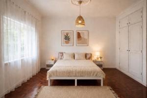 a bedroom with a bed and a pendant light at Charneca Mar & Sol in Charneca