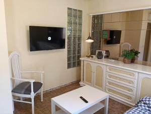 a living room with a tv and a white dresser at Kitsch apartment in Rasquera