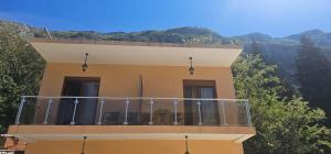 a building with a balcony with chairs on it at Apartments Agnes in Dobrota