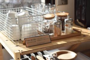 a shelf with many glasses and a sign on it at Blue Hour Kanazawa in Kanazawa