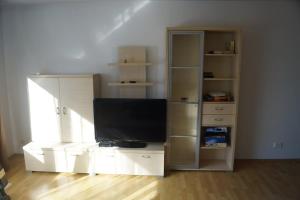 a living room with a television on a white entertainment center at Ferienwohnung Notos- Eislingen in Eislingen