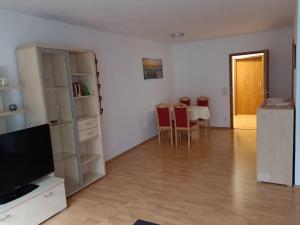 a living room with a television and a table with chairs at Ferienwohnung Notos- Eislingen in Eislingen +14 photos