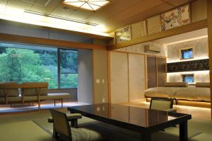 a living room with a table and chairs at Arima Onsen Gekkoen Korokan in Kobe
