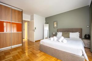 a bedroom with a large white bed and wooden floors at Charming Maisonette In Southern Suburbs in Athens