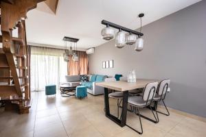 a living room with a table and chairs and a couch at Charming Maisonette In Southern Suburbs in Athens +12 photos