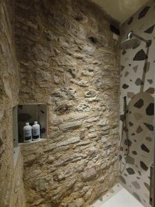 a bathroom with a stone wall with a shower at Loft in Love in Spello +20 photos