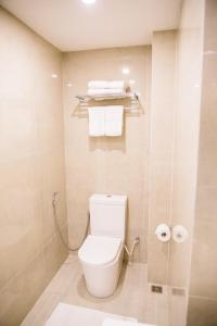 a bathroom with a toilet and towels in it at Venue Colombo in Colombo