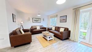 a living room with two couches and a table at Old England Cottage - Part of the The Bay Filey Holiday Village with pool, gym and direct beach access, pub, restaurant, tennis and meadows walks in Filey