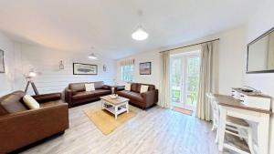 a living room with a couch and a table at Old England Cottage - Part of the The Bay Filey Holiday Village with pool, gym and direct beach access, pub, restaurant, tennis and meadows walks in Filey