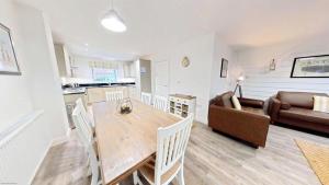 a kitchen and living room with a table and a couch at Old England Cottage - Part of the The Bay Filey Holiday Village with pool, gym and direct beach access, pub, restaurant, tennis and meadows walks in Filey +39 photos