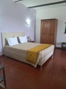 a bedroom with a bed and a wooden cabinet at Monte das Galhanas in Monte do Pigeiro +69 photos