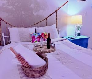a white bed with a table with a bottle of wine on it at Escape Caribeño in Levittown