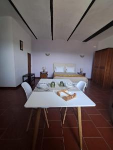 a living room with a white table and a bed at Monte das Galhanas in Monte do Pigeiro