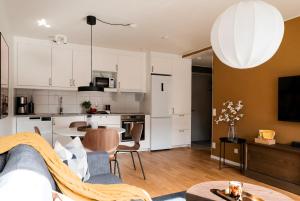 a living room and kitchen with a couch and a table at Guestly Homes - Central Premium Suite 1BR in Västerås +33 photos