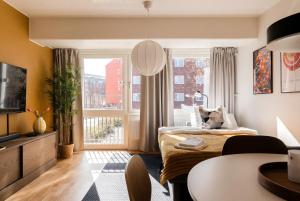 a living room with a bed and a window at Guestly Homes - Central Premium Suite 1BR in Västerås