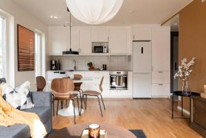 a kitchen and living room with a couch and a table at Guestly Homes - Central Premium Suite 1BR in Västerås
