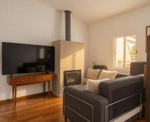 a living room with a couch and a flat screen tv at Akistay Guest House - Caparica in Costa da Caparica