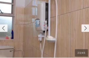 a bathroom with a blow dryer on the wall at Roje's Oasis in Jinja +13 photos