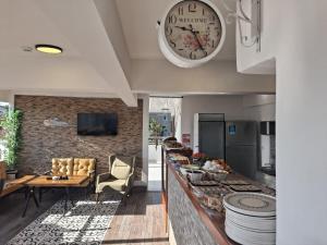 a kitchen with a counter with a clock on the wall at Hotel Efesian B&B City Center - Harbour in Kuşadası