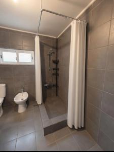 a bathroom with a toilet and a shower with a shower curtain at Akistay Guest House - Caparica in Costa da Caparica +12 photos