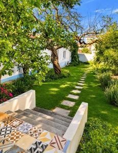 a garden with a bench and a pathway at Akistay Guest House - Caparica in Costa da Caparica