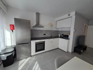 a kitchen with white cabinets and a stove top oven at Flexi flat Gosselies Providence 12 in Charleroi