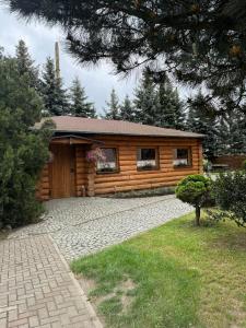 a log cabin with a driveway in front of it at Hotel Jan in Zgorzelec