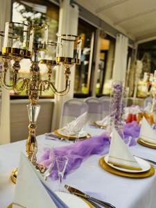 a table with white table cloth and gold and purple napkins at Hotel Jan in Zgorzelec