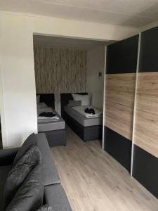 a small room with two beds and a couch at Ferien-Landleben in Löbnitz