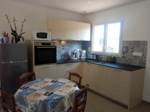 a small kitchen with a table and a microwave at Gîte du Bois de Drancourt in Drancourt