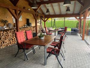 a patio with wooden tables and chairs and a fireplace at Ferien-Landleben in Löbnitz