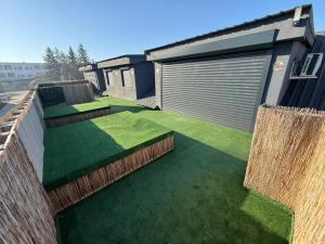 a house with a yard with green grass at Intimissima apartman in Odorheiu Secuiesc